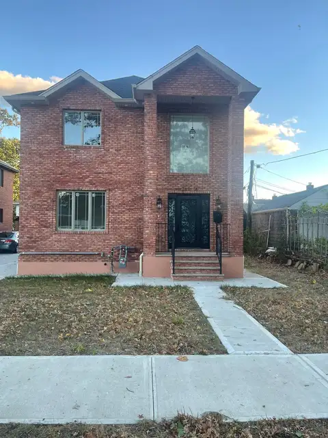 New concrete walkway in front of a brick house